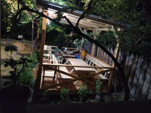 a wooden pergola with a picnic table in a backyard at Vardzia Old Village in Vardzia