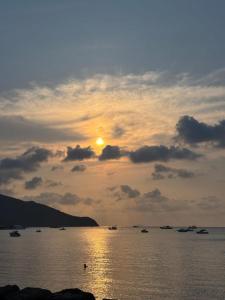 a sunset over a body of water with boats at Bangsaray Beach Condo B414 บางเสร่ บีช in Bang Sare