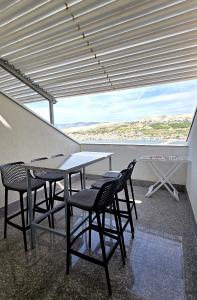 a table and chairs on a balcony with a view at Apartments Sv. Jelena 2 in Pag