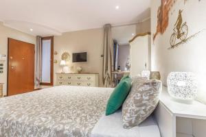 a bedroom with a large bed with green pillows at A due passi dal Castello in Ferrara
