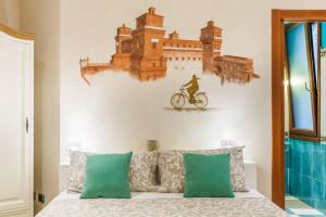 a bedroom with a bed with a bike on the wall at A due passi dal Castello in Ferrara