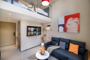 a living room with a blue couch and a table at Mihua International Apartment - Guangzhou Yangang Subway Station Branch in Guangzhou +51 photos