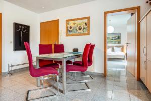 comedor con sillas rojas y mesa en Wohnung Anker im Haus Maxi, en Ostseebad Sellin