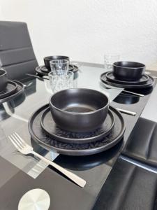 a table with black plates and a bowl on top of it at 2 Zimmer Apartment mit Sauna in Pforzheim +7 photos