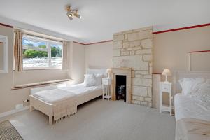 a bedroom with two beds and a fireplace at Whitehall Cottage in Painswick
