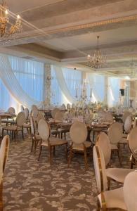 una sala banchetti con tavoli, sedie e lampadario a braccio di Hotel Queen Vera a Mamaia