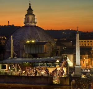 a view of a building with a clock tower at night at Hotel Valadier in Rome
