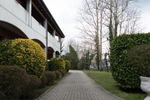 a brick walkway next to a building with bushes at Hotel Mariuccia in Varese