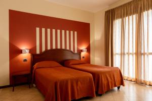 a hotel room with two beds and a large window at Hotel Mariuccia in Varese