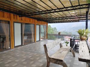 a wooden bench on a balcony with a view at Xóm Mới HomeStay in Dồng Văn