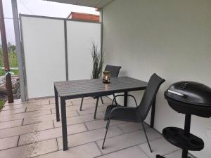 a table and two chairs and a grill on a patio at Studio 5min Blausee / 20min Interlaken / WIFI in Kandergrund +13 photos