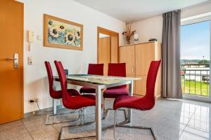 comedor con sillas rojas y mesa en Wohnung Anker im Haus Maxi, en Ostseebad Sellin 18 fotos más