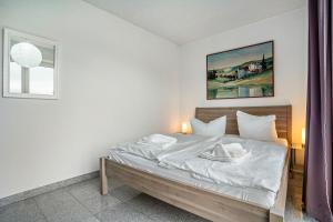 Un dormitorio con una cama con sábanas blancas y una ventana. en Wohnung Anker im Haus Maxi, en Ostseebad Sellin