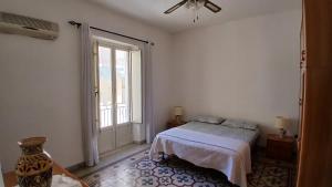 a white bedroom with a bed and a window at Da Cristina appartamento in Sciacca