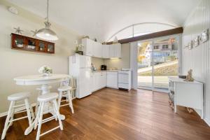 une cuisine avec des appareils électroménagers blancs, une table et des tabourets dans l'établissement Waterfront condo -shop-beach-bike-boat-pool-chill, à Saugatuck