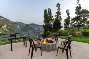 a group of chairs sitting around a fire pit at StayVista at Kurinji Amaze Kodai with WiFI & Heater in Kodaikānāl +48 photos