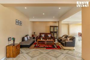 a living room with two couches and a table at StayVista at Kurinji Amaze Kodai with WiFI & Heater in Kodaikānāl
