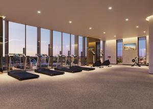 a gym with a row of treadmills and ellipticals at High-Rise Balcony Unit with City Views Gym Pool in Melbourne