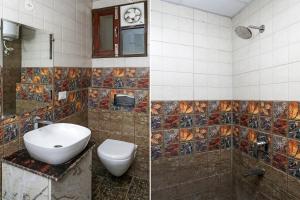 two pictures of a bathroom with a toilet and a sink at Super Hotel O The Signature Inn in Indirapuram