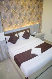 - une chambre avec un grand lit dans l'établissement Hotel vinayak shree airport indore, à Indore