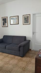 a blue couch in a living room with two pictures on the wall at Da Cristina appartamento in Sciacca