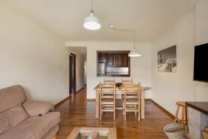 a living room with a couch and a table and chairs at Apto A Pie De Pistas En La Molina in La Molina
