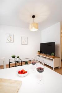 a living room with two glasses of wine and a bowl of fruit at Mountain Soul l Wifi l Céntrico l Luminoso in Sabiñánigo