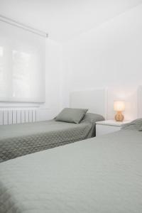a bedroom with two beds and a table with a lamp at Mountain Soul l Wifi l Céntrico l Luminoso in Sabiñánigo
