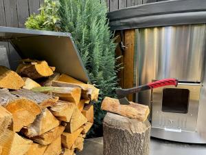 a large axe sticking out of a pile of wood at Garden Residence - The Garage in Drahobudice