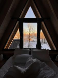 a bed in a room with a large window at Grehit House in Kozmacz