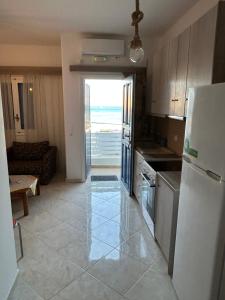 a kitchen with a refrigerator and a living room at Deep Blue in Anafi
