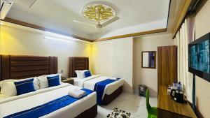 una habitación de hotel con dos camas y un televisor de pantalla plana en Hotel Blue Sky Mirpur, en Dhaka