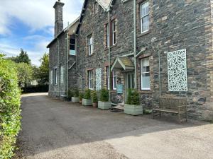 a brick building with a bench in front of it at Bethby Beck Apartment Keswick at The Lairbeck in Keswick