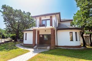 Una casa blanca con un balcón encima. en Csillag Villa, en Balatonalmádi