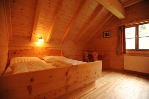 a bedroom in a log cabin with a large bed at Almstallhütte in Pruggern