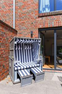 a bench sitting in front of a brick building at Ferienhaus Fischerstuuv in Carolinensiel