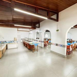 カルダス・ノバスにあるHotel Roma - Caldas Novasの広い客室で、建物内にテーブルと椅子が備わります。