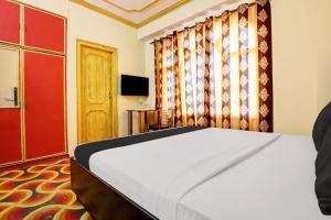 シムラーにあるHotel O Mall Road Kali-Bari Temple Formerly Baseraのベッドルーム1室(ベッド1台、赤いドア付)
