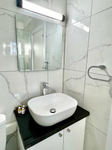a bathroom with a white sink and a mirror at Fully Equipped One Bedroom APT in Limassol