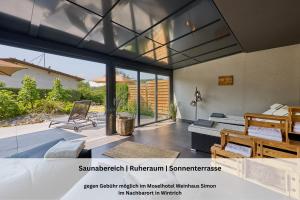 a room with a bed and a bedroom with glass doors at FeWo - EG Apartment Mosel- & Weinquartier, Terrasse, Parkplatz, moderne Küche bis 4 Personen in Piesport