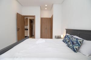 a bedroom with a large white bed with two pillows at Zenitude in Casablanca +52 photos