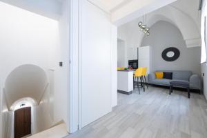 サン・ヴィート・デイ・ノルマンニにあるCasa Vacanze Centro Storicoの白い壁のリビングルームとダイニングルーム