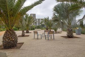 a patio with chairs and palm trees and buildings at Zenitude in Casablanca