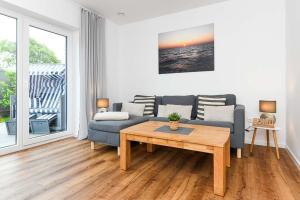 a living room with a couch and a table at Ferienhaus Fischerstuuv in Carolinensiel