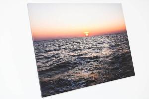a sunset over the ocean with the sun in the horizon at Ferienhaus Fischerstuuv in Carolinensiel