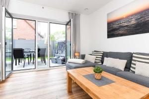 a living room with a couch and a table at Ferienhaus Fischerstuuv in Carolinensiel