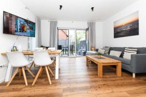 a living room with a table and a couch at Ferienhaus Fischerstuuv in Carolinensiel +53 photos