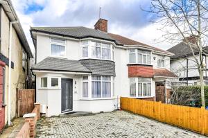 a white house with a fence in front of it at Stylish House Near Wembley Stadium in London