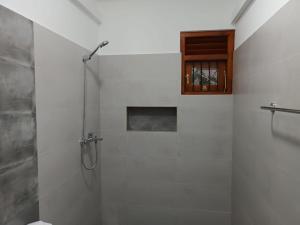 MoragallaにあるTwins Beach Villaの白いバスルーム(シャワー、キャビネット付)