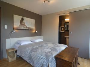 a bedroom with a bed and a painting on the wall at Luxury Villa with Sauna in Francorchamps